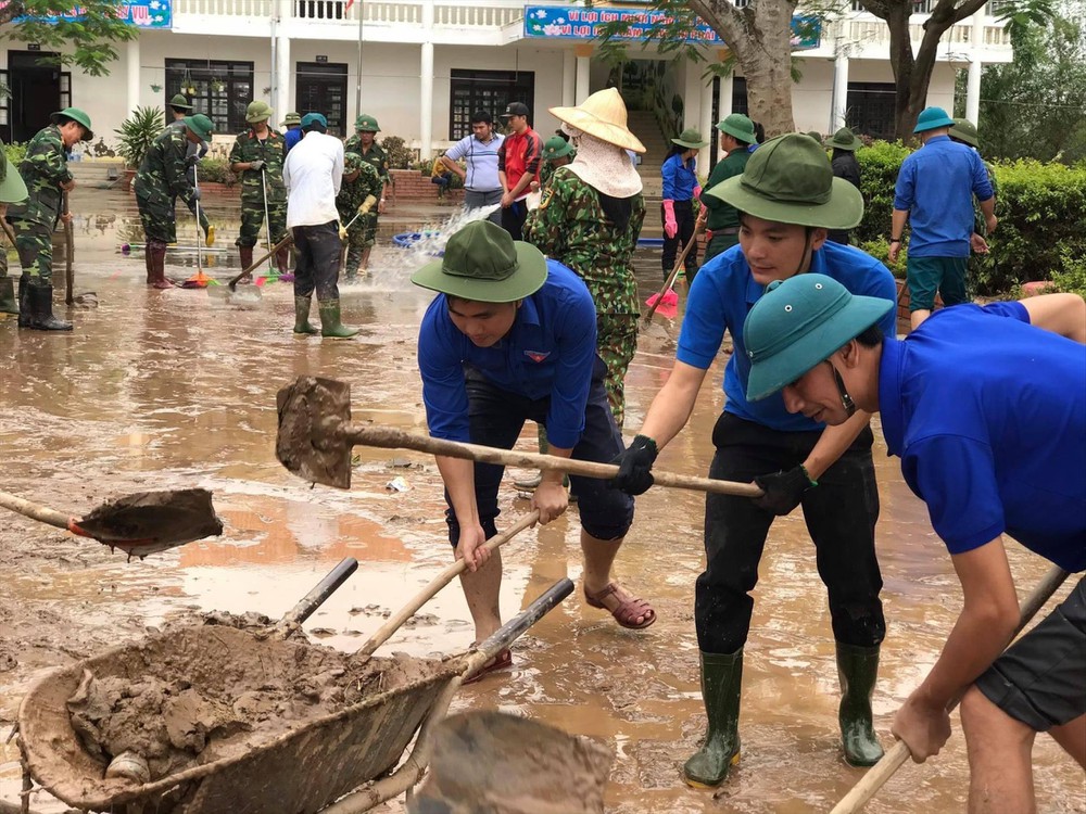 Thanh niên tình nguyện và những người lính trẻ Quảng Bình hỗ trợ nhân dân khắc phục hậu quả lũ lụt.